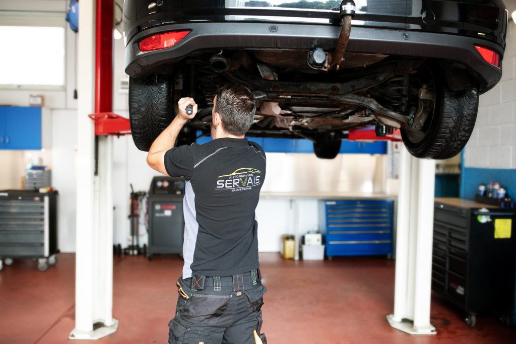 Techniker kontrolliert Fahrzeug in der Garage Servais vor technischer Fahrzeugkontrolle